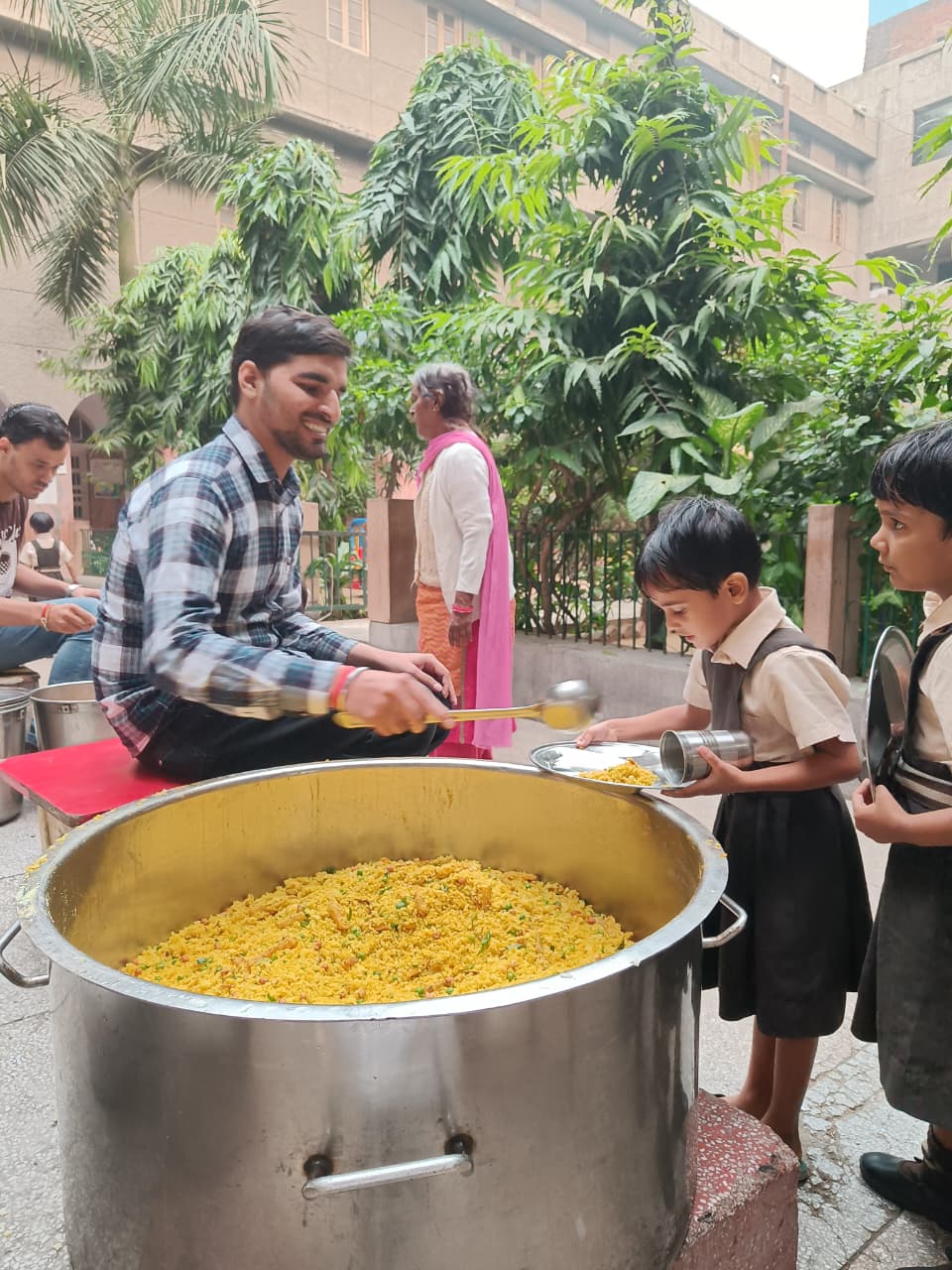 Feeding Universe volunteer serving food to children