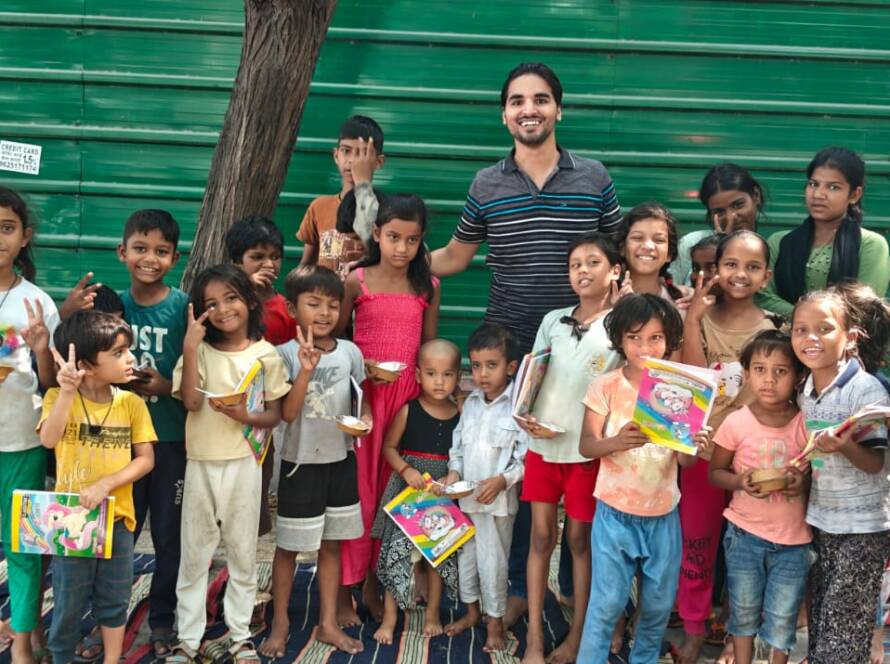 Children receiving books and stationery from Feeding Universe