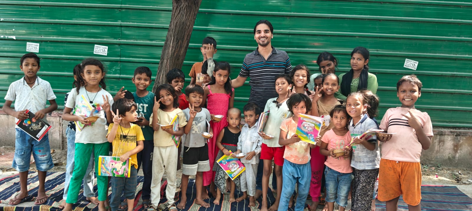 Children receiving books and stationery from Feeding Universe