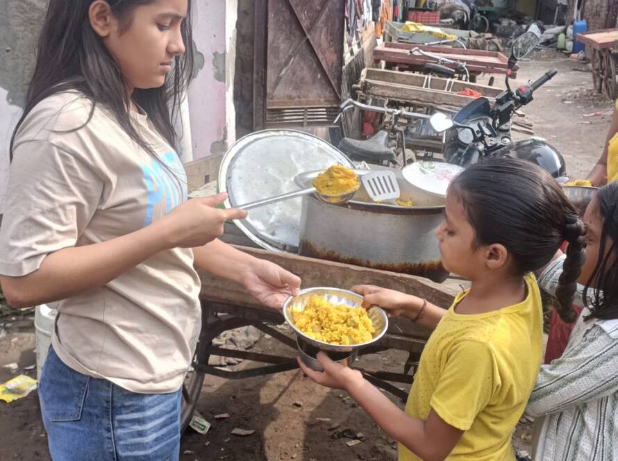A Feeding Universe volunteer serving food to a child at the Sunday drive in Delhi