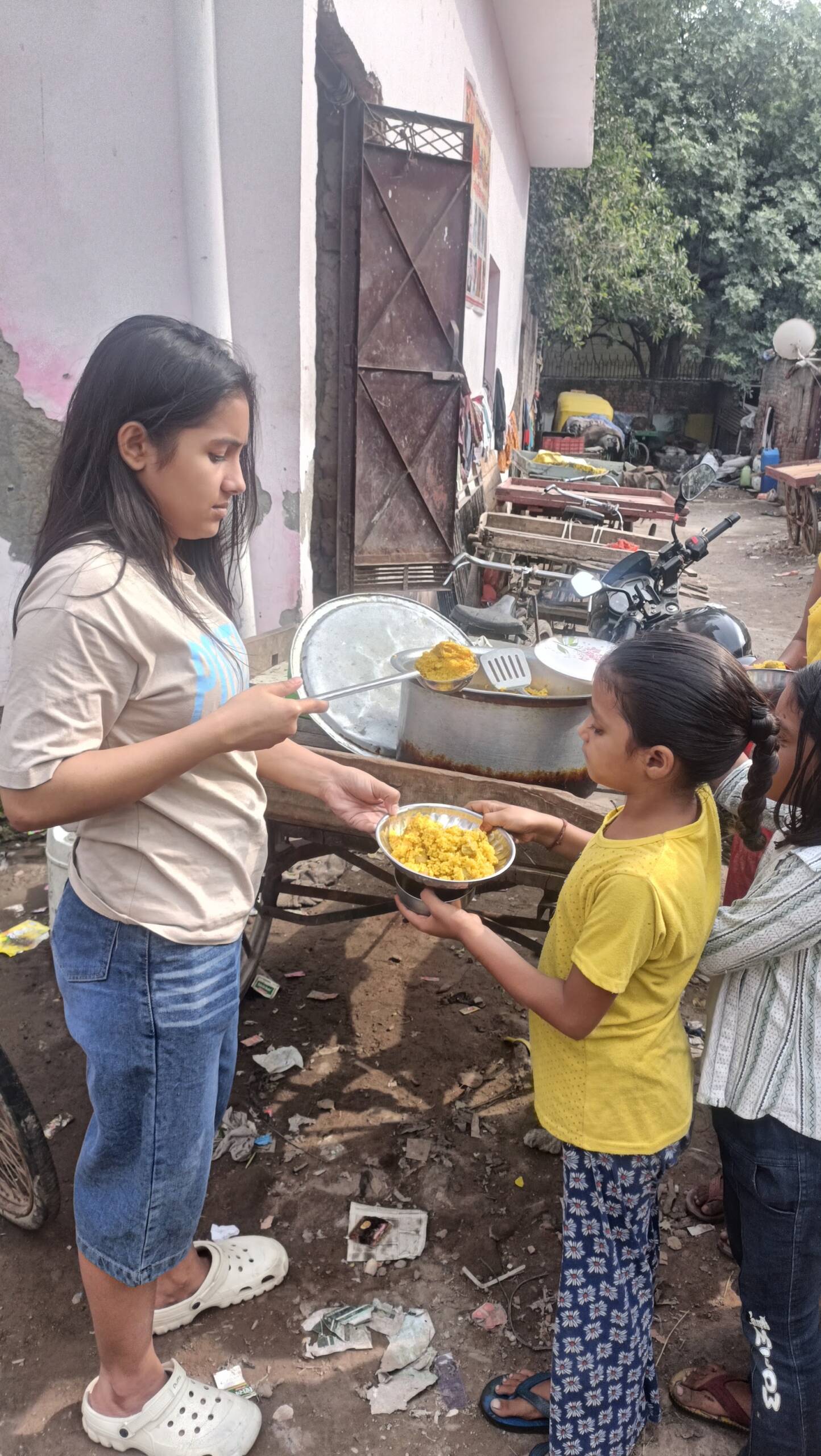 A Feeding Universe volunteer serving food to a child at the Sunday drive in Delhi